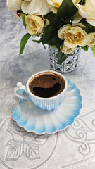 Still life with a bouquet of roses and a cup of coffee