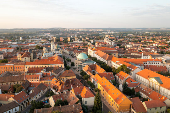 Aerial view of picturesque rooftops and historic buildings in vibrant sunset light, Pecs, Hungary.
