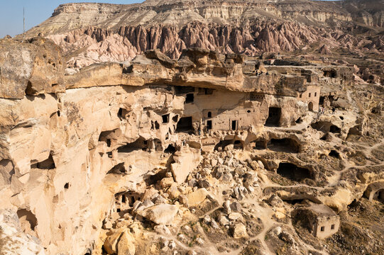 Aerial view of ancient cave dwellings and unique rock formations in a picturesque landscape, Cavusin, Turkiye.