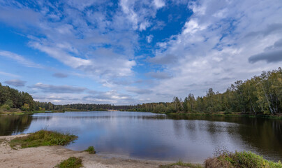 A lake with a cloudy sky in the background