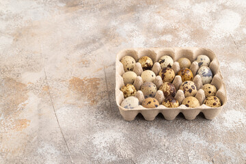 Pile of Raw quail eggs on a brown concrete. side view, copy space.