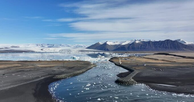 Iceland's majestic landscape unfolds in this stunning aerial image, where glacier water flows effortlessly