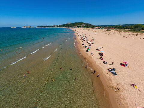 Aerial view of a beautiful sandy beach with people and colorful umbrellas along the coastline of the Black Sea, Sile, Turkey.