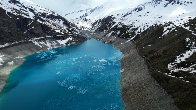4k Drone Aerial Reverse Flying Shot Of Vibrant Blue Glacial Water Of Lac de Moiry Dam In Grimentz Switzerland