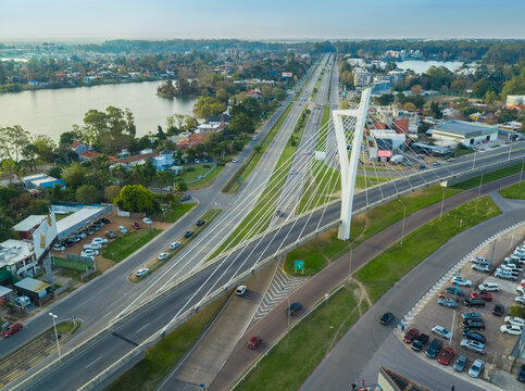 Aerial view of av de las americas bridge over a lake with cars and urban architecture, Montevideo, Uruguay.