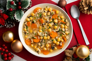 Chickpea and rice soup with mushrooms and vegetables. Top view table with Christmas decorations.