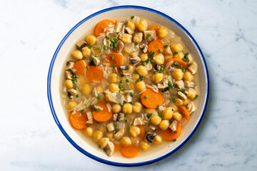 Chickpea and rice soup with mushrooms and vegetables. Top view table with  decorations.