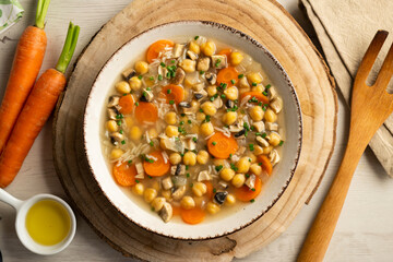 Chickpea and rice soup with mushrooms and vegetables. Top view table with  decorations.