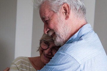 Happy mature couple embracing tenderly, showcasing romantic love and support despite their age. The photo captures the heartfelt connection of seniors in a loving and comforting moment, highlighting 