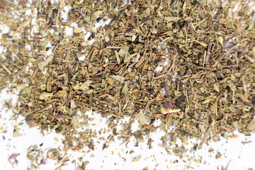 Dry basil spice seasoning macro texture on white background.