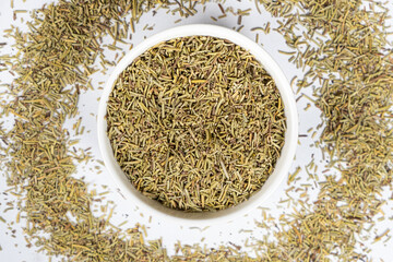 Seasoning dried rosemary in a plate, top view of chopped rosemary close-up