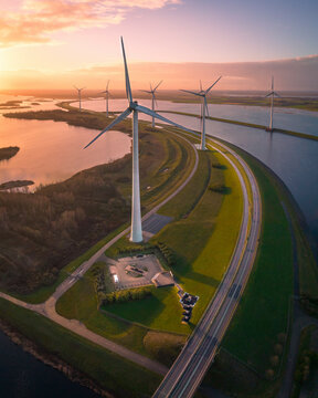 Aerial view of Krammersluizen windpark with wind turbines and a scenic road at sunrise, Bruinisse, Netherlands.