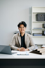 Young business man working at office with laptop, tablet and taking notes on the paper..