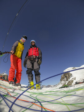 Two adventurers prepare for a winter paragliding flight