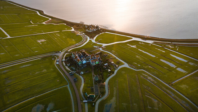 Aerial view of a picturesque village with charming houses by a tranquil lake at sunrise, Marken, Netherlands.