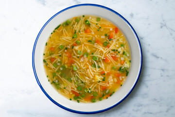 Vegetable soup with green beans and red pepper. Top view table with  decoration.