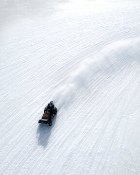 Aerial view of ice racing on the frozen ijsselmeer with people and snowmobiles, Cornwerd, Netherlands.