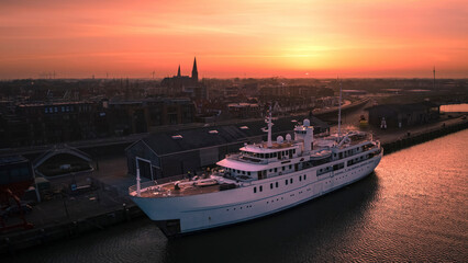 Harlingen, Netherlands - 25 February 2021: Aerial view of a beautiful harbour at sunrise with boats moored in the tranquil waters, Harlingen, Netherlands.