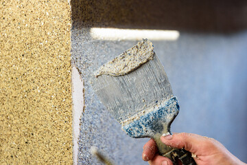 Applying decorative mosaic plaster on the wall.