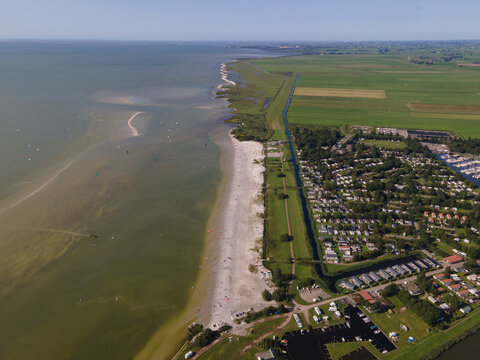 Aerial view of kite surfing at a beautiful beach along the tranquil ijsselmeer, Workum, Netherlands.
