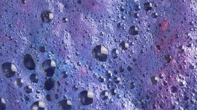 Drilling fluid. Pink and blue foam mixing in purple bubbles when dissolving a salt cosmetic bombs, macro. Cosmetics background