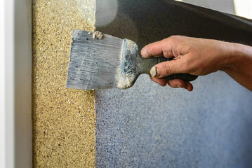 Applying decorative mosaic plaster on the wall.