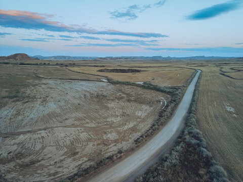 Aerial view of beautiful barren landscape with a tranquil road through the countryside, Bardenas Reales, Navarre, Spain.