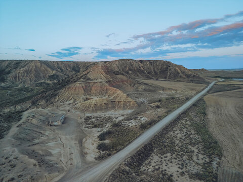Aerial view of the beautiful desert landscape with a winding road in Bardenas Reales, Cortes, Navarre, Spain.