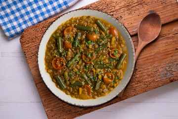 Lentil soup with green beans and cherry tomatoes. Top view table with  decoration.