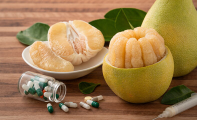 Fresh pomelo fruit and medicine adverse drug reaction interaction design concept.