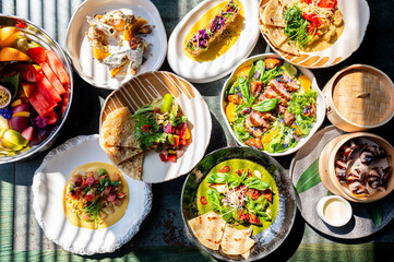 variety of colorful dishes arranged on a table, showcasing a diverse and appetizing meal. vibrant...