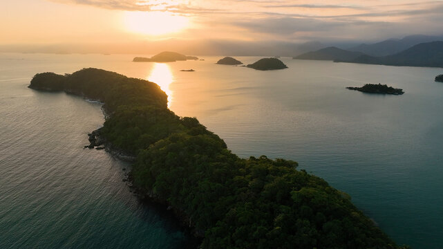 Aerial view of a serene tropical island at sunset surrounded by calm ocean waters, Paraty, Brazil.