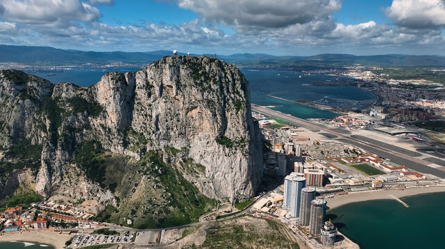 Aerial view of the majestic rock of Gibraltar overlooking the ocean and cityscape with an airport, Gibraltar.