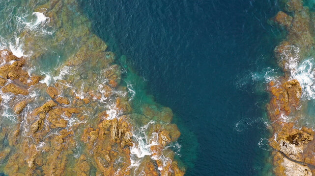 Aerial view of scenic coastline with beautiful ocean waves and rocks, Capelo, Azores, Portugal.