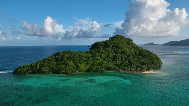 Aerial view of a tropical island with turquoise waters and lush greenery, Satitoa, Samoa.