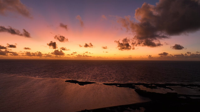 Aerial view of a breathtaking tropical island at sunset with vibrant colors reflecting on the ocean, Bonaire, Caribbean Netherlands.