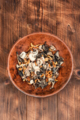 Dried mushrooms pile on a wooden table.