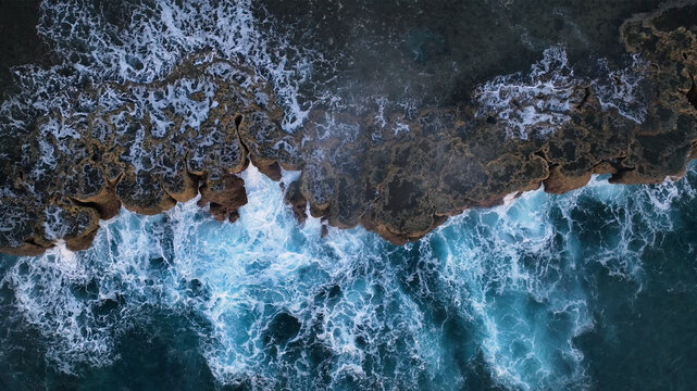 Aerial view of tropical island reef with crashing waves and azure ocean, Utulau, Tonga.