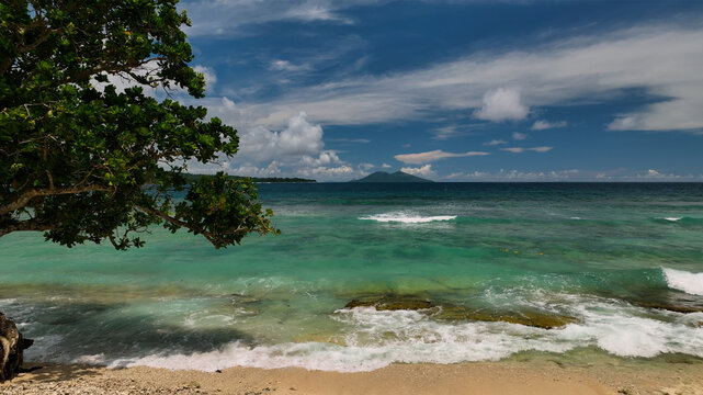 Aerial view of pristine tropical island with azure waters, palm trees, and gentle waves, Shefa, Vanuatu.