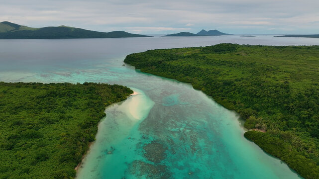 Aerial view of a beautiful tropical island with lush greenery and pristine beach surrounded by azure ocean waves, Shefa, Vanuatu.
