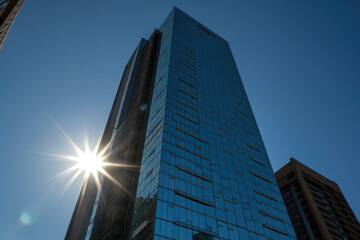 Obraz premium generated illustration of low-angle view of a modern glass building in the city.