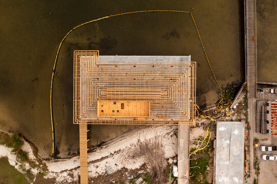 Aerial view of a construction site adjacent to Squid Lips restaurant with water and platforms, Sebastian, Florida.