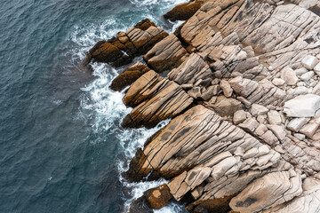 Aerial view of rugged coastal scenery with clear blue ocean and rocky shore, Terence Bay, Canada.
