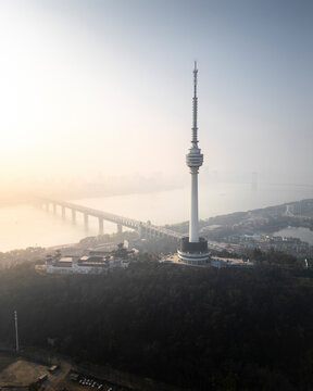 Aerial view of the beautiful skyline featuring Tortoise Mountain TV Tower, a serene river, and modern architecture in Wuhan, China.