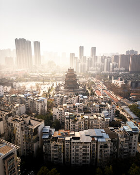 Aerial view of gui yuan temple surrounded by skyscrapers and a bustling urban landscape at sunset, wuhan, china.