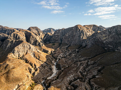 Aerial view of majestic rugged mountains and a beautiful valley under a blue sky with clouds, Toliara - Tulear, Madagascar.