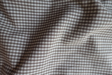 Soft folds on cotton fabric with grey and white gingham pattern