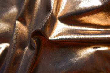 Flowy bronze nylon and spandex lame fabric in soft folds
