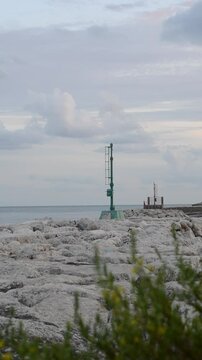 The seamark on the shore lights up. Cloudy sky with the light of seamark. Sea coast navigation.