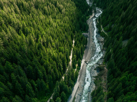 Aerial view of lush forest and winding river in Gran Paradiso National Park, Cogne, Italy.